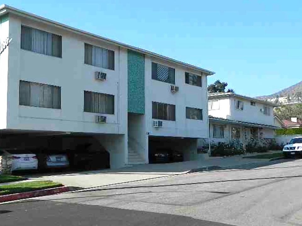 Three-story apartment building with covered parking in a hillside neighborhood