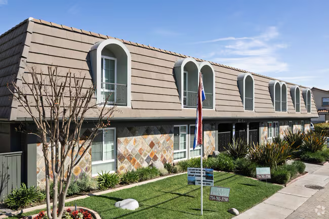 Charming mansard-roof apartment community with stone façade and curb appeal