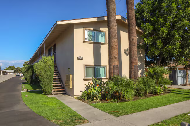 Classic Southern California fourplex with palm trees and exterior staircase