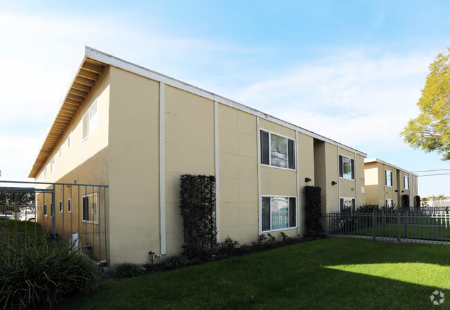 Two-story apartment building with courtyard entry and ornamental trees