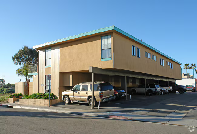 Commercial-style multifamily with covered carport and teal trim