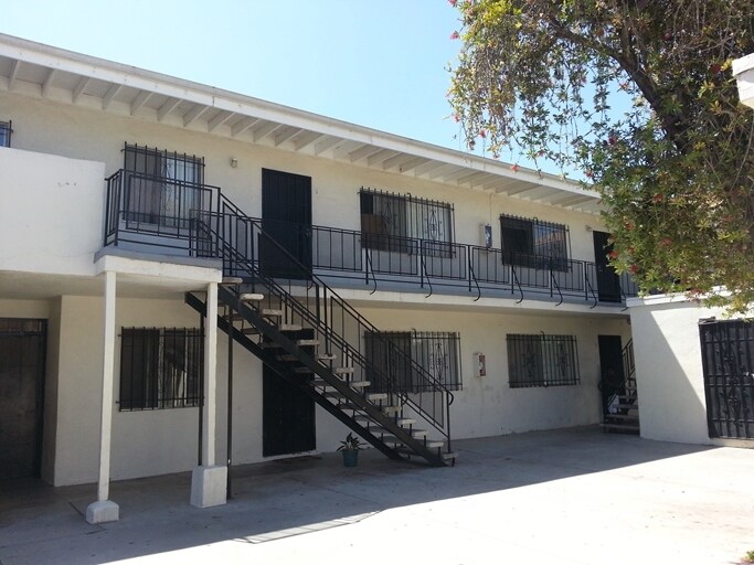 Two-story walk-up apartments with exterior metal staircase and iron balconies
