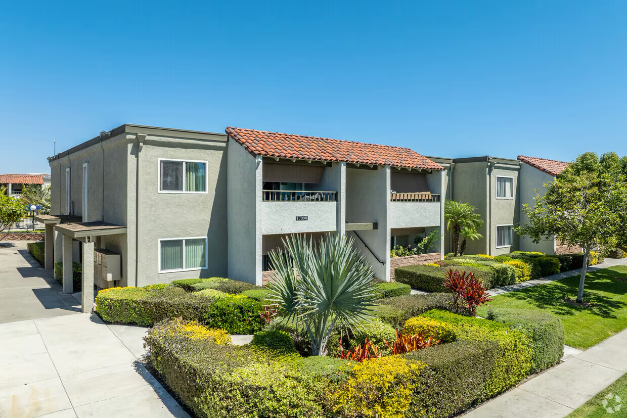 Upscale garden-style community with red tile roof and manicured shrubs